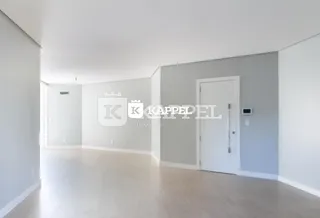 Hall de entrada com paredes claras e piso de madeira.