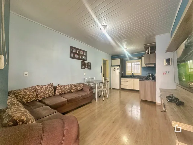 Sala de estar com sofá e área de jantar em um apartamento.