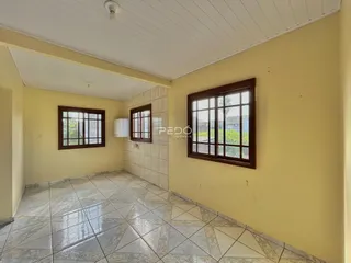 Uma sala com piso de cerâmica e paredes amarelas em um imóvel no Brasil.