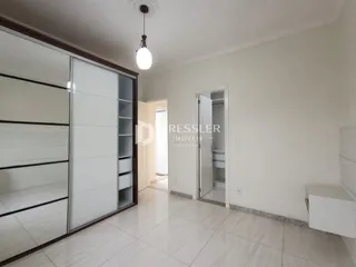Hall de entrada com paredes brancas e piso de cerâmica claro.