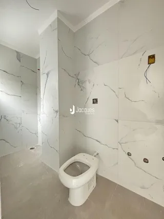 Foto de um banheiro com revestimento de mármore nas paredes.