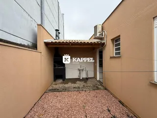 Fachada externa de um imóvel em Lajeado, Brasil, mostrando um pátio com piso de cascalho.