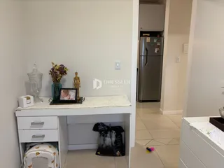 Hall com um armário branco e porta de acesso a uma cozinha é visível na imagem.