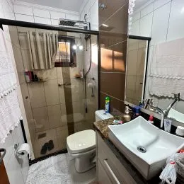Foto de um banheiro com revestimento de azulejos brancos.