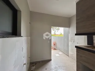 Vista de um corredor interno com acesso a uma área externa em Lajeado.