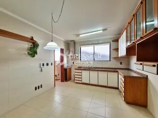 Hall de entrada com revestimento de piso claro e armários de madeira.