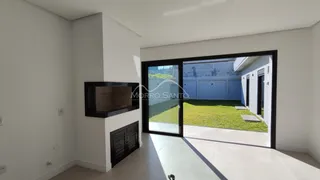 Sala de estar com lareira e porta de vidro que dá acesso ao quintal.