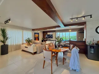 Sala de estar moderna com piso claro e vigas de madeira.