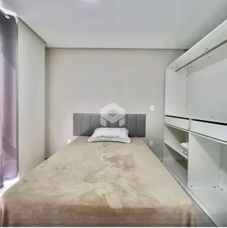 Quarto com cama grande e paredes brancas em um imóvel.