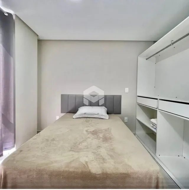 Quarto com cama grande e paredes brancas em um imóvel.