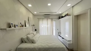 Quarto com cama e estantes brancas em um apartamento.