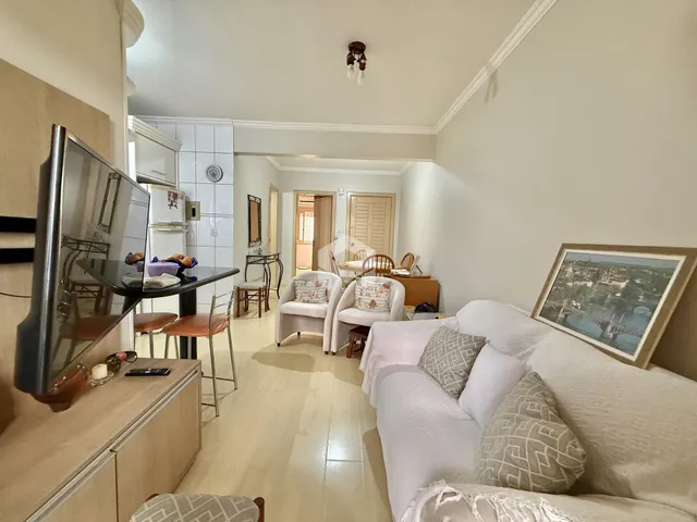 Sala de estar com sofá branco e piso de madeira clara.