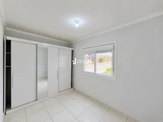 A sala apresenta paredes brancas e piso de cerâmica.