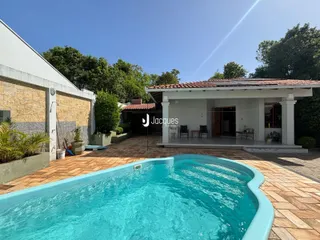 Piscina e área externa com piso de tijolo no quintal.