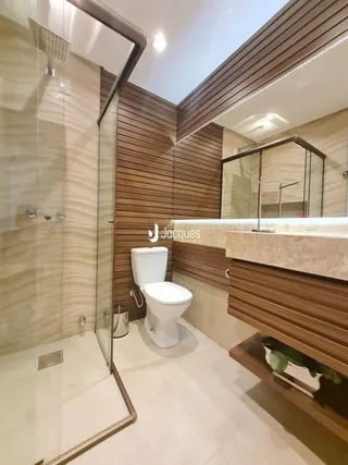 Foto de um banheiro com box de vidro e piso de cerâmica.