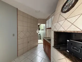Vista de um corredor interno com revestimento de azulejos claros.