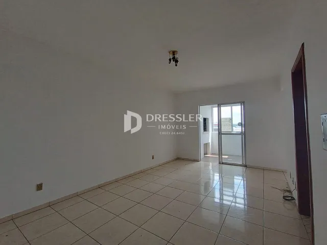 Ambiente interno de uma sala com piso de cerâmica clara.