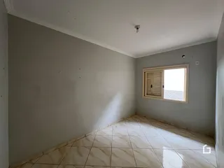 Interior de um cômodo com piso de cerâmica e parede branca.