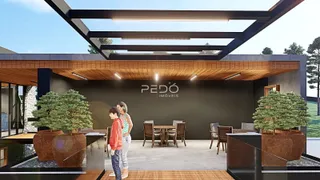 Vista de uma área de lazer coberta com piso de madeira e árvores em um imóvel.