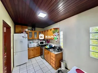 Cozinha com armários de madeira e piso cerâmico.