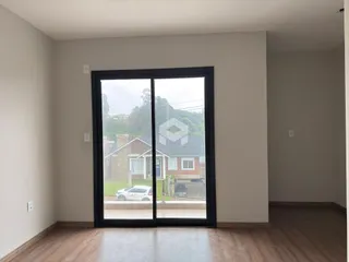 Ambiente interno com piso de madeira e porta de vidro voltada para o exterior.