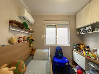 Quarto com cabeceira de madeira e janela em um imóvel no Brasil.