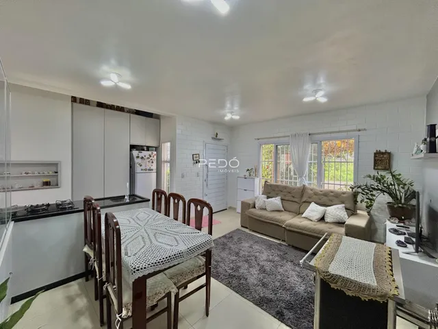 Sala de estar com mesa de jantar e sofá em um imóvel no Brasil.