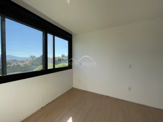 Uma foto interna mostra uma sala com grande janela com vista para a paisagem.