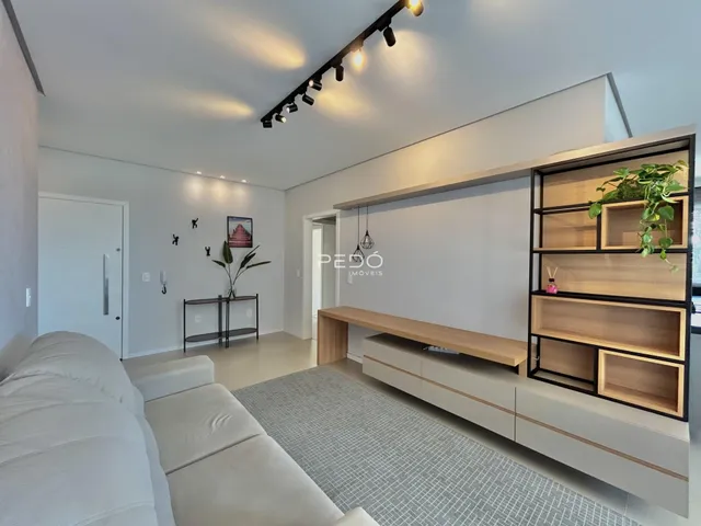 Sala de estar moderna com sofá e estante de madeira.