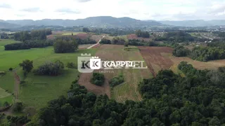 Vista aérea de uma paisagem rural com campos e vegetação.