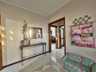 Sala de estar com parede clara e piso de cerâmica