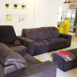 Foto de uma sala de estar com um sofá grande de cor escura.
