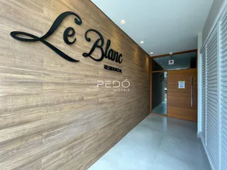 Hall de entrada com parede de madeira e detalhes em letras pretas.