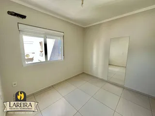 Foto de um ambiente interno com paredes brancas e piso de cerâmica.