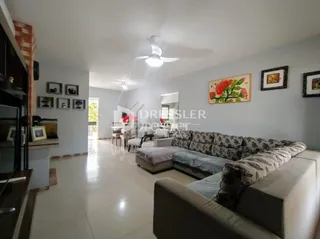 Sala de estar com piso de cerâmica e sofá no interior de uma residência.