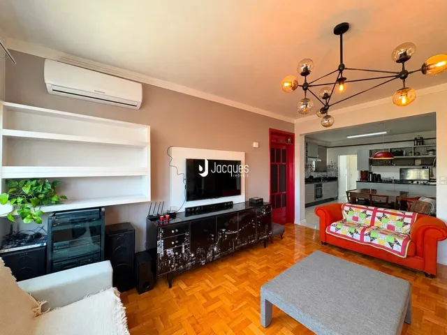 Sala de estar com piso de madeira e televisão na sala.