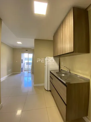 Hall de entrada com piso de cerâmica e armários de madeira.