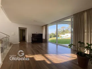 Sala de estar com piso de madeira e vista para o jardim externo.