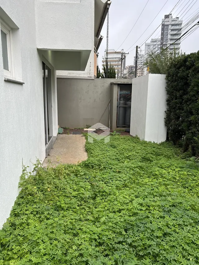 Fachada lateral de uma residência com jardim e muro em Lajeado.