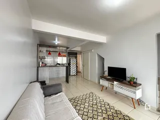 Ambiente interno de uma sala de estar com cozinha integrada em Lajeado.