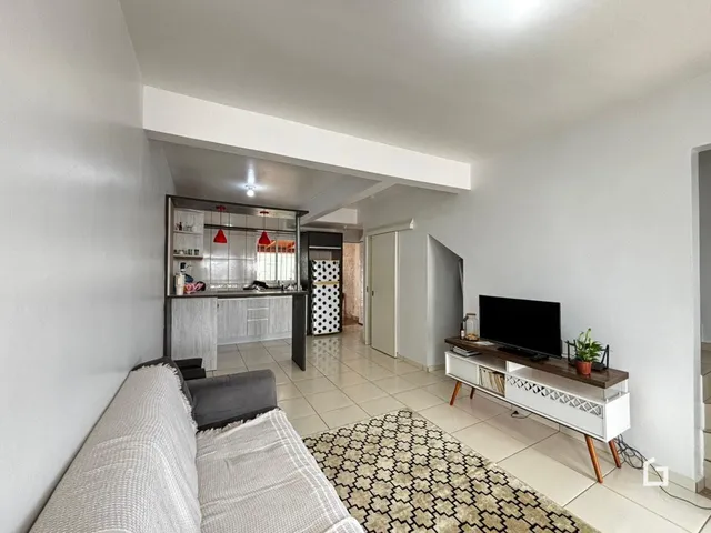 Ambiente interno de uma sala de estar com cozinha integrada em Lajeado.