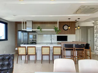 Foto de uma cozinha moderna com ilha e armários em madeira em um apartamento em Lajeado.