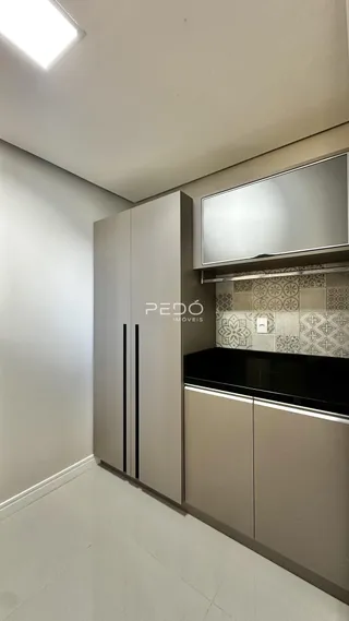 Vista interna de uma cozinha moderna com armários em tons neutros.