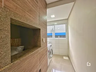 Interior de uma área com revestimento de parede e passagem para o banheiro.