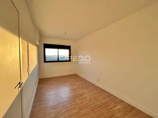 Ambiente interno com piso de madeira e vista da cidade.