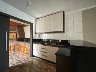 Vista da cozinha com armários e piso de cerâmica.