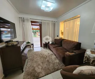 Sala de estar com sofá marrom e piso claro.