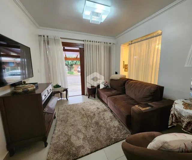 Sala de estar com sofá marrom e piso claro.