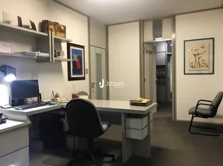 Foto de um escritório interno com estantes e uma mesa de trabalho.