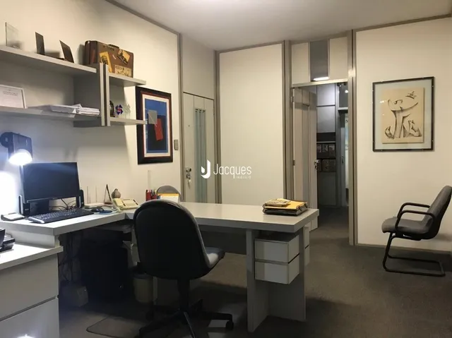 Foto de um escritório interno com estantes e uma mesa de trabalho.